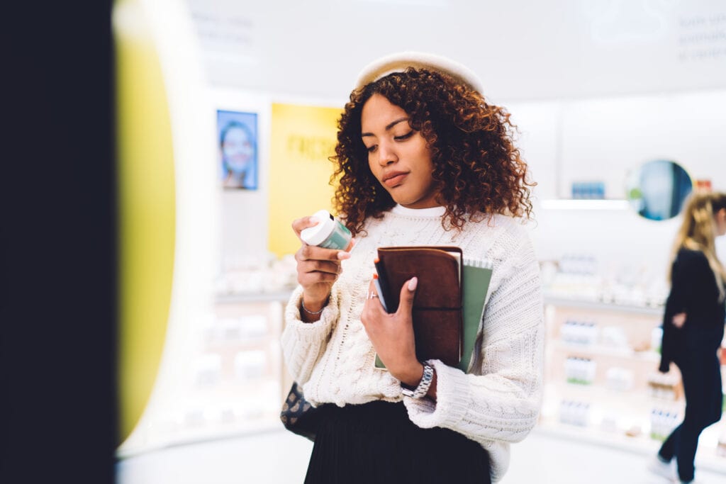 Woman reading the ingredients of a feminine hygiene product for vaginal health. 